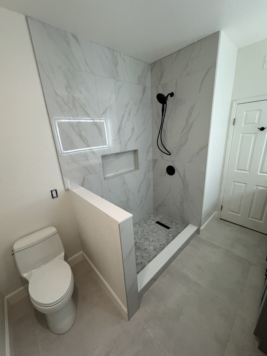 Walk-in shower installation with tile walls and modern bathroom layout