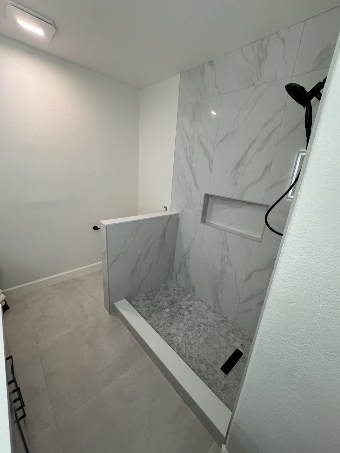 Bathroom renovation in progress showing shower base and waterproofing preparation