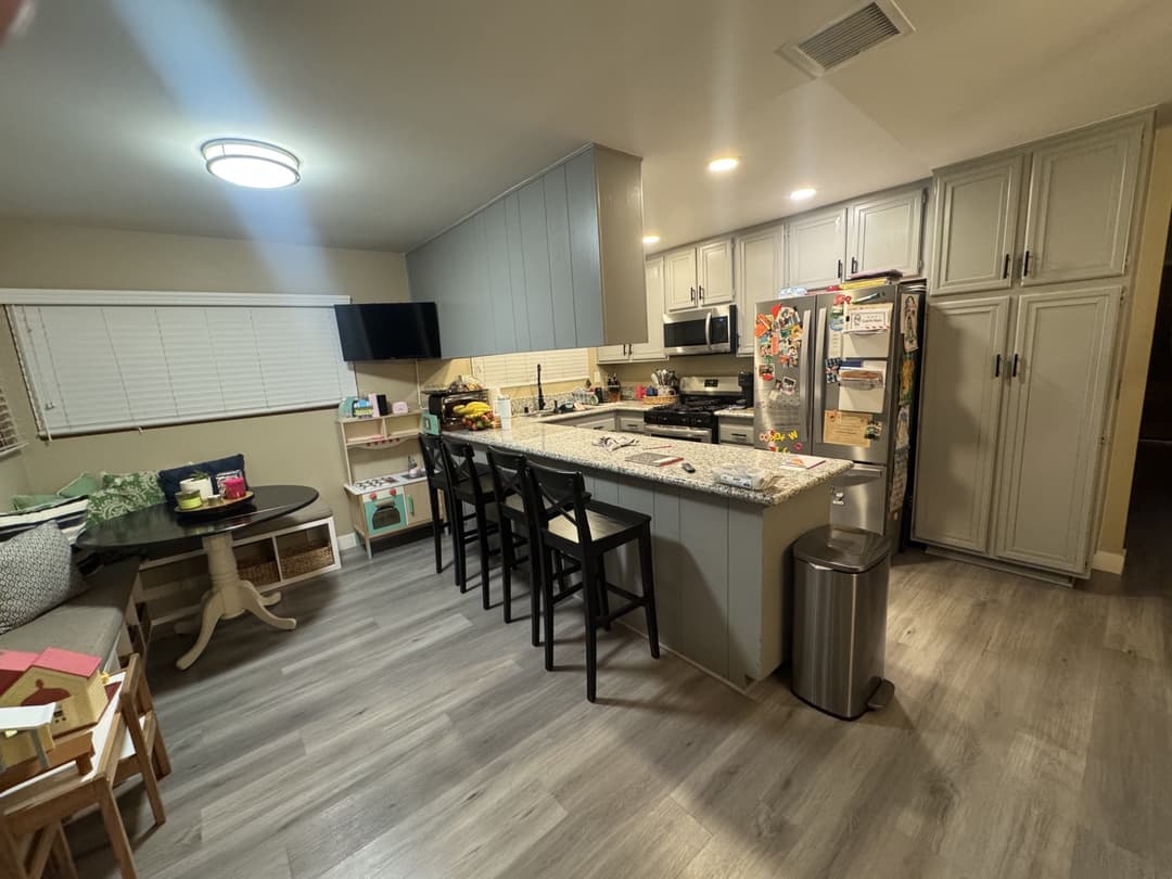 Completed kitchen remodel with large island, modern lighting, and open-concept layout