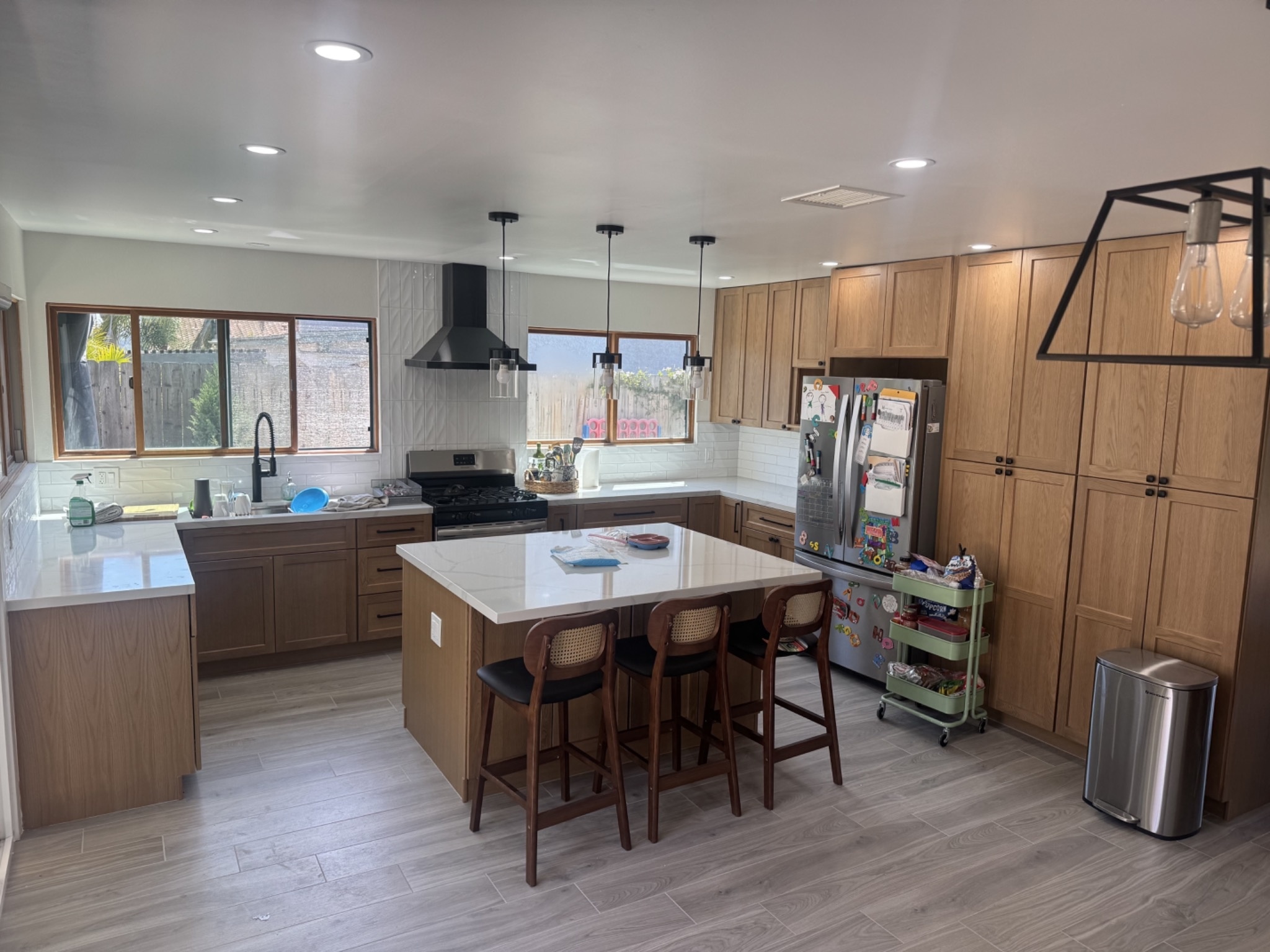Modern kitchen remodel with custom cabinetry, island seating, and updated lighting in San Diego home